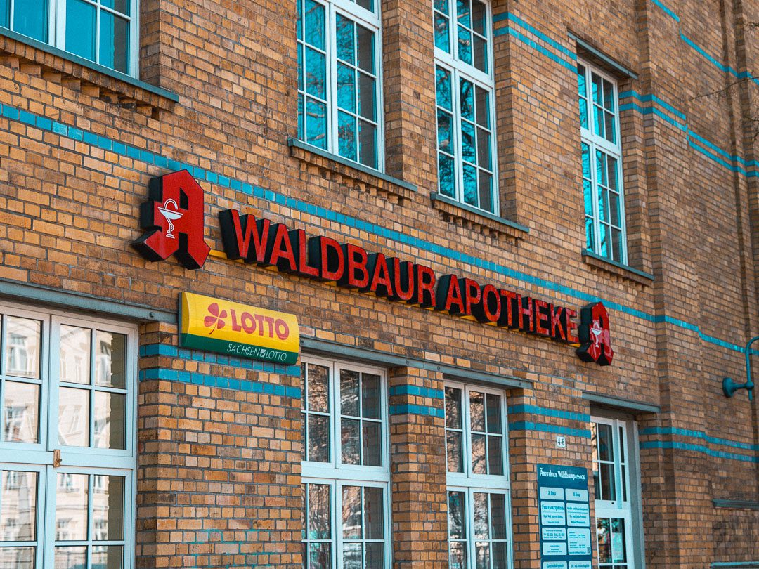 Backsteinfassade mit Apotheke und Lotto-Annahmestelle im Erdgeschoss